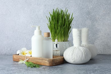 Photo of Spa composition with wheatgrass on grey table