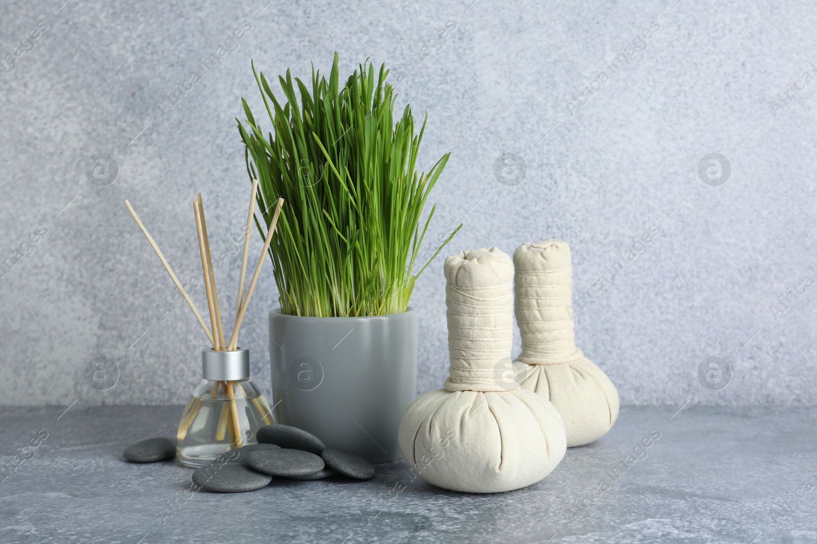 Photo of Spa composition with wheatgrass on grey table