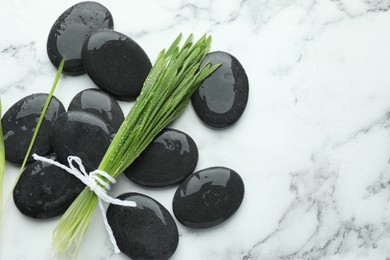 Photo of Spa stones and wheatgrass on white marble background, flat lay