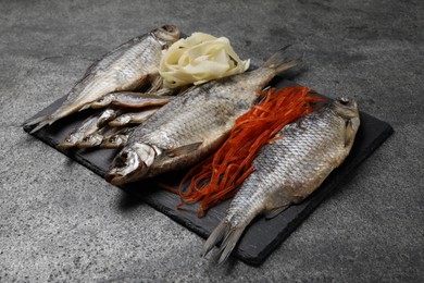 Many different dried fish snacks on grey table