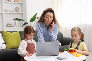 Photo of Work-family balance. Single mother talking on smartphone and her daughters at home