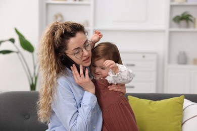 Photo of Work-family balance. Single mother talking on smartphone and her daughter indoors