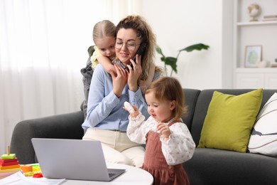 Photo of Work-family balance. Single mother talking on smartphone and her daughters at home