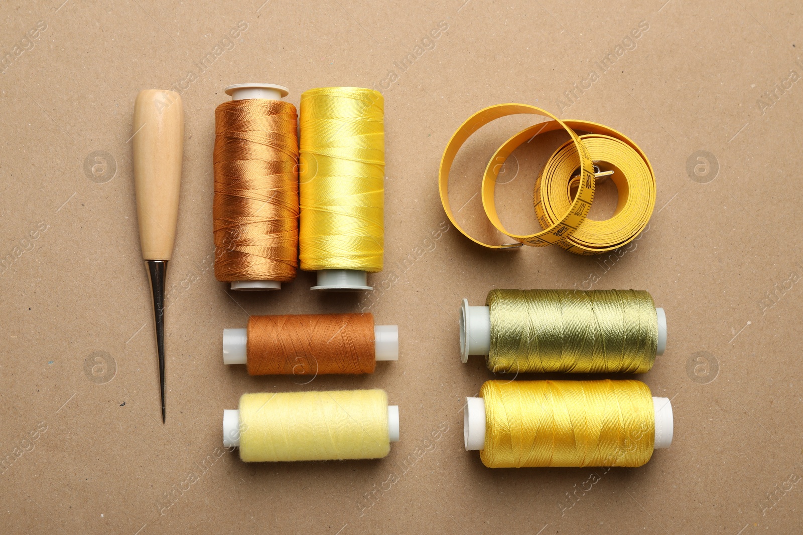 Photo of Different sewing supplies on beige background, flat lay