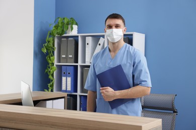 Photo of Receptionist in medical mask with clipboard at counter in clinic