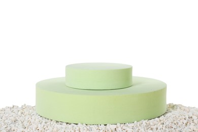 Photo of Round podiums on pebbles against white background. Presentation of product