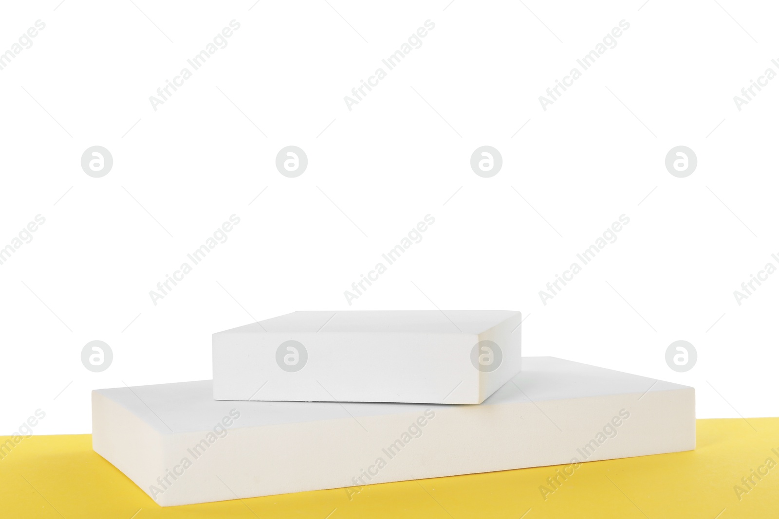 Photo of Podiums on yellow surface against white background. Presentation of product