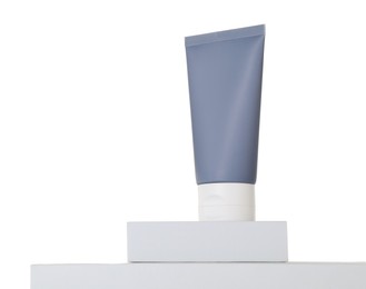 Tube of sun protection product on podium against white background