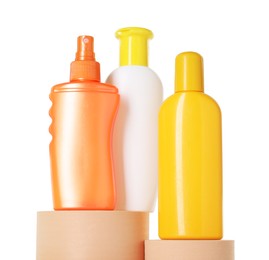 Photo of Different sun protection products on podiums against white background