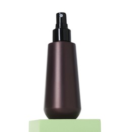 Bottle of sun protection product on podium against white background