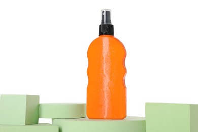 Photo of Bottle of sun protection product and podiums against white background