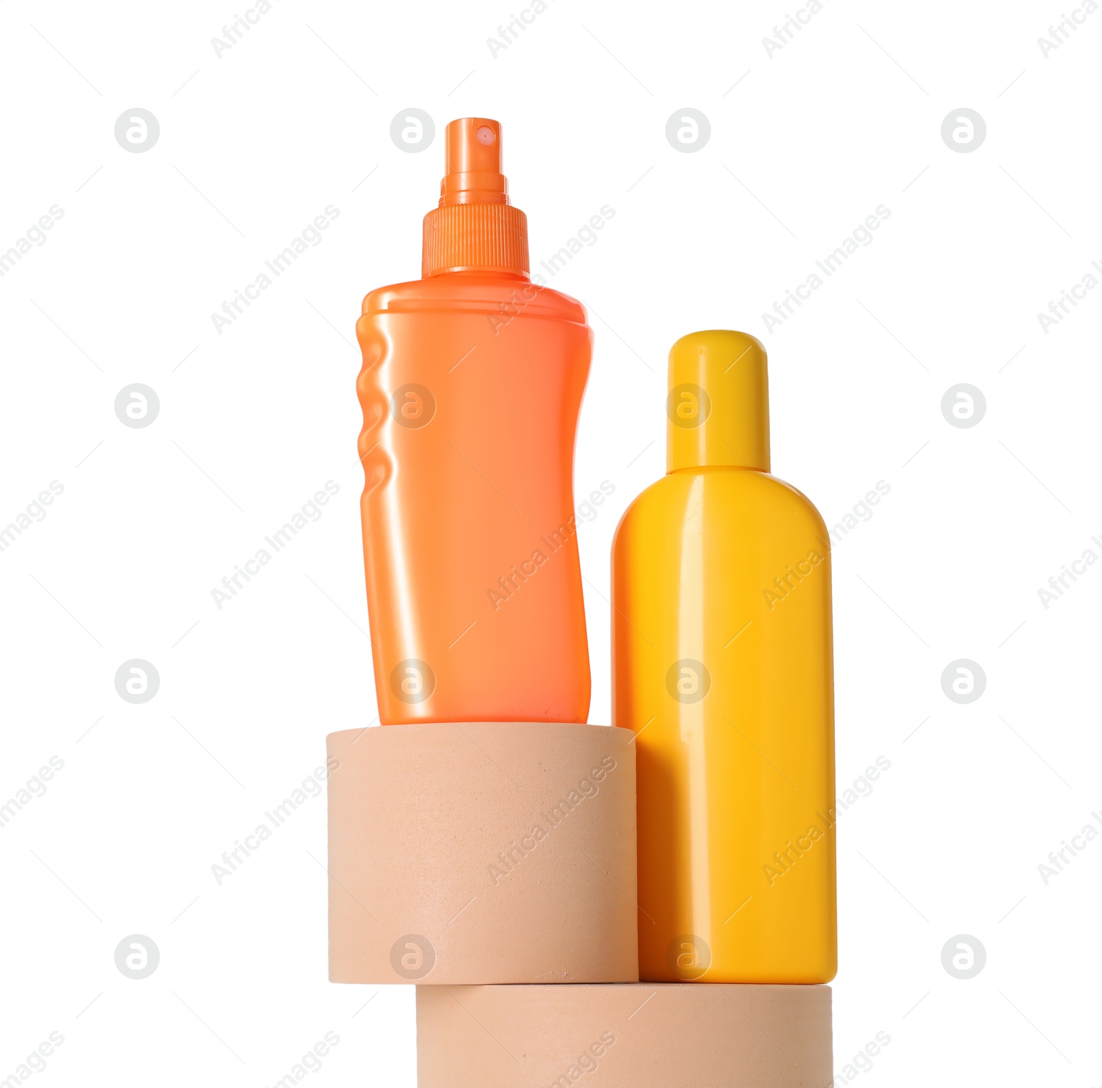 Photo of Bottles of sun protection products on podiums against white background