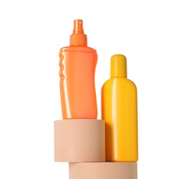 Bottles of sun protection products on podiums against white background