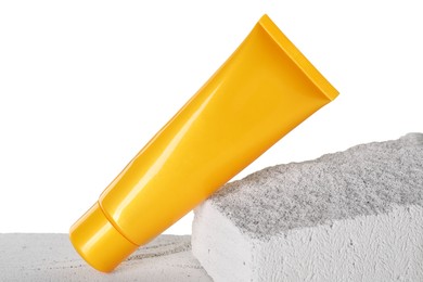 Tube of sun protection product on concrete block against white background