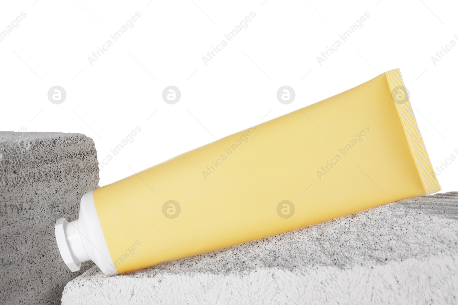 Tube of sun protection product on concrete block against white background Photo of Tube of sun protection product on concrete block against white background