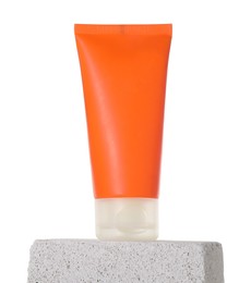 Tube of sun protection product on concrete block against white background