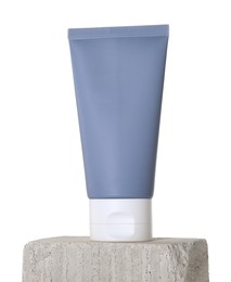 Tube of sun protection product on concrete block against white background