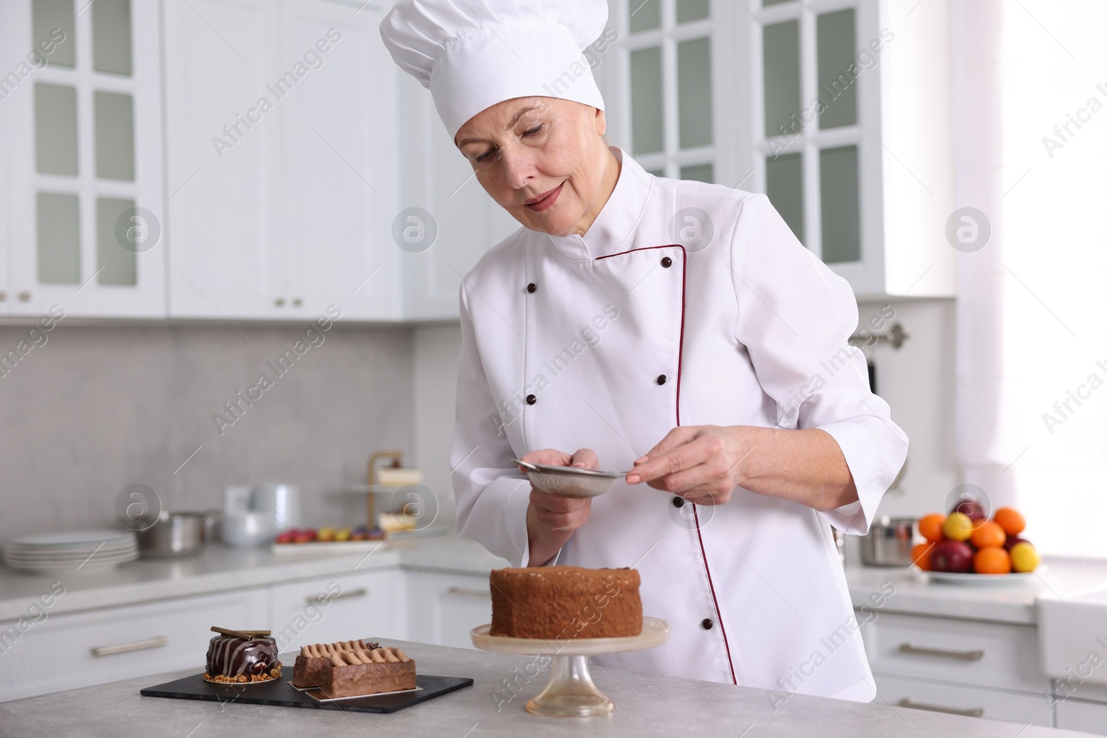 Photo of Professional pastry chef making cake at table in kitchen