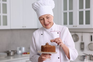 Professional pastry chef making cake in kitchen