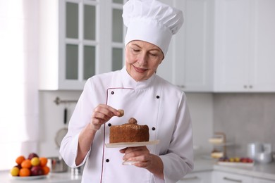 Professional pastry chef making cake in kitchen