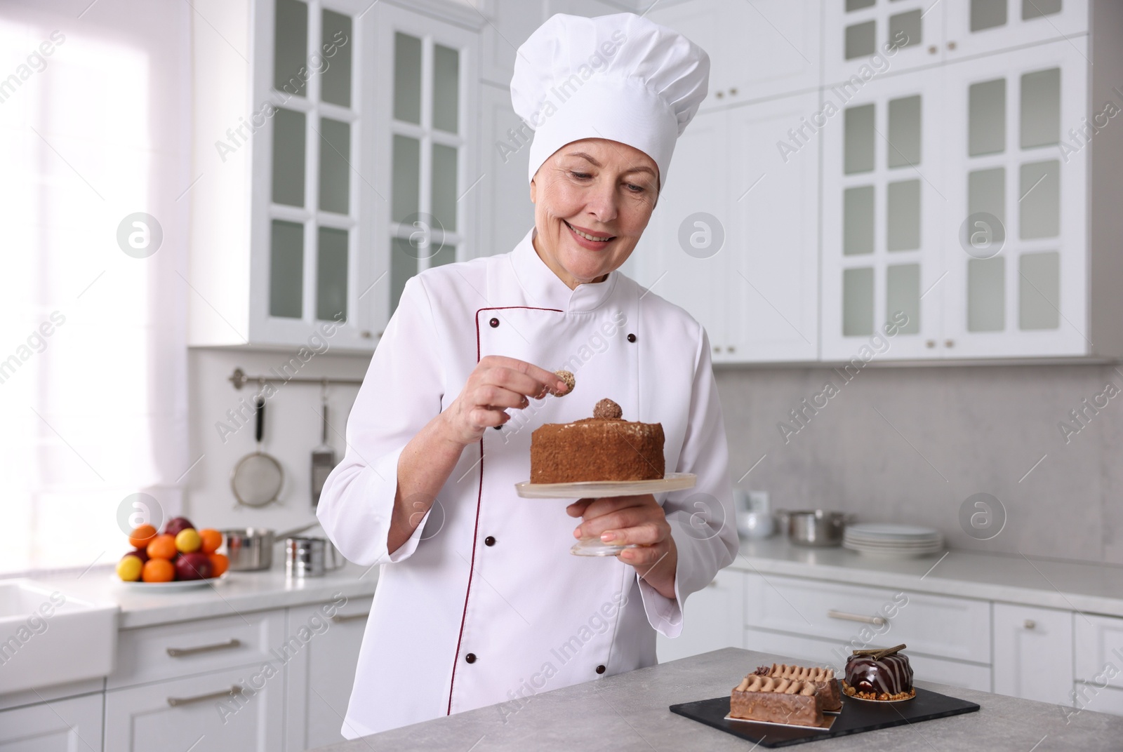 Photo of Professional pastry chef making cake at table in kitchen