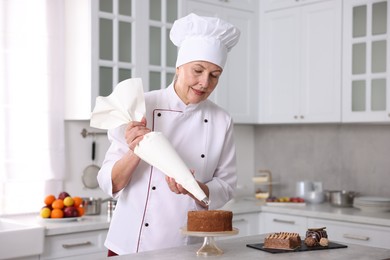 Photo of Professional pastry chef making cake at table in kitchen