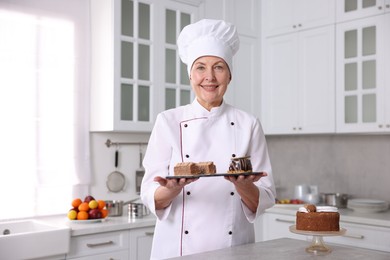 Professional pastry chef with desserts at table in kitchen