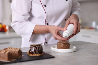 Photo of Professional pastry chef making desserts at table in kitchen, closeup