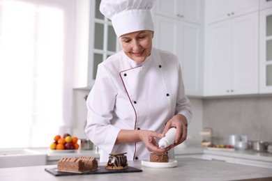 Photo of Professional pastry chef making dessert at table in kitchen