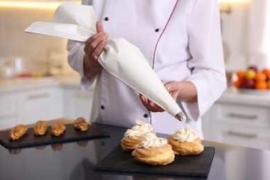 Photo of Professional pastry chef making desserts at table in kitchen, closeup