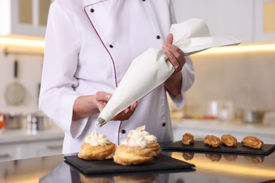 Photo of Professional pastry chef making desserts at table in kitchen, closeup