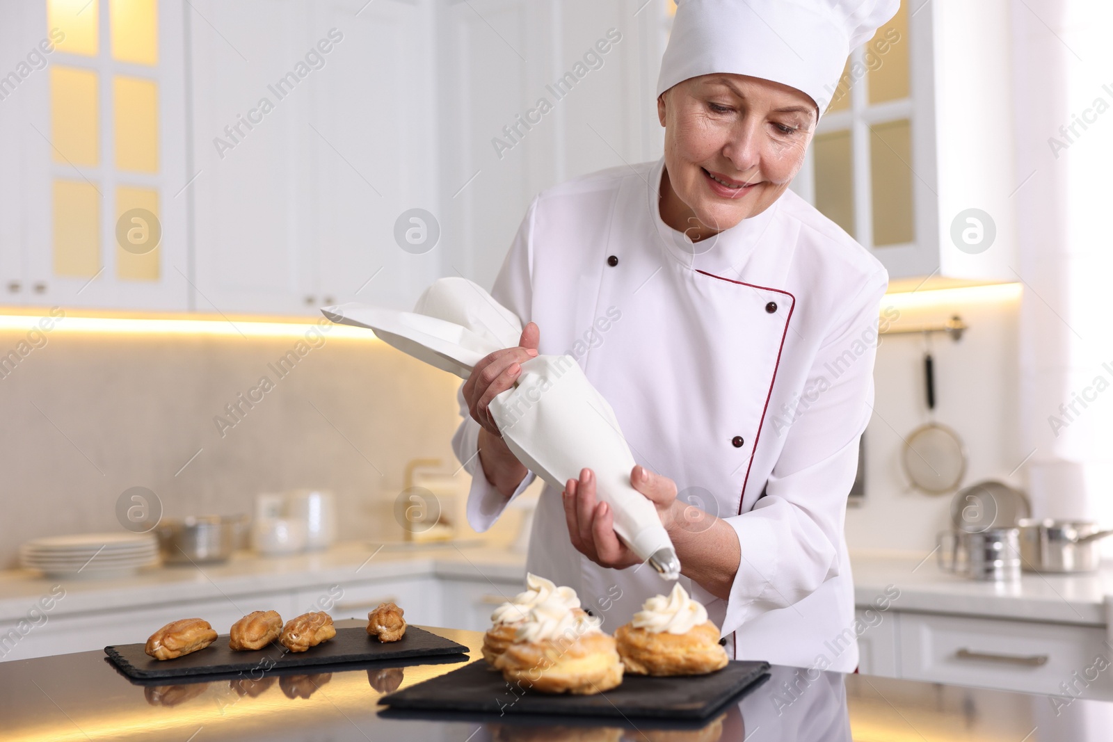 Photo of Professional pastry chef making desserts at table in kitchen