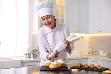 Photo of Professional pastry chef making desserts at table in kitchen