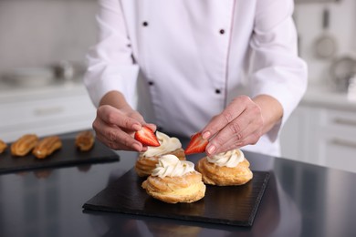 Photo of Professional pastry chef making desserts at table in kitchen, closeup