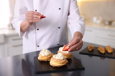 Photo of Professional pastry chef making desserts at table in kitchen, closeup