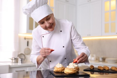 Professional pastry chef making desserts at table in kitchen