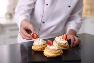 Photo of Professional pastry chef making desserts at table in kitchen, closeup