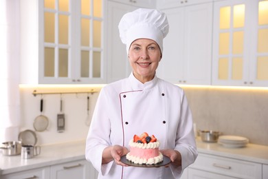 Professional pastry chef with cake in kitchen