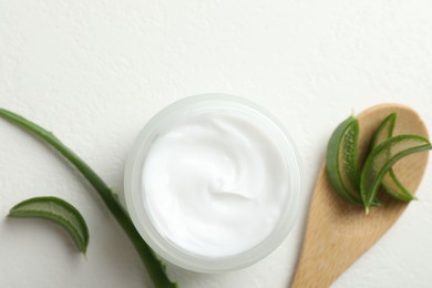 Photo of Moisturizing cream with extract of aloe vera and cut leaves on white textured background, flat lay