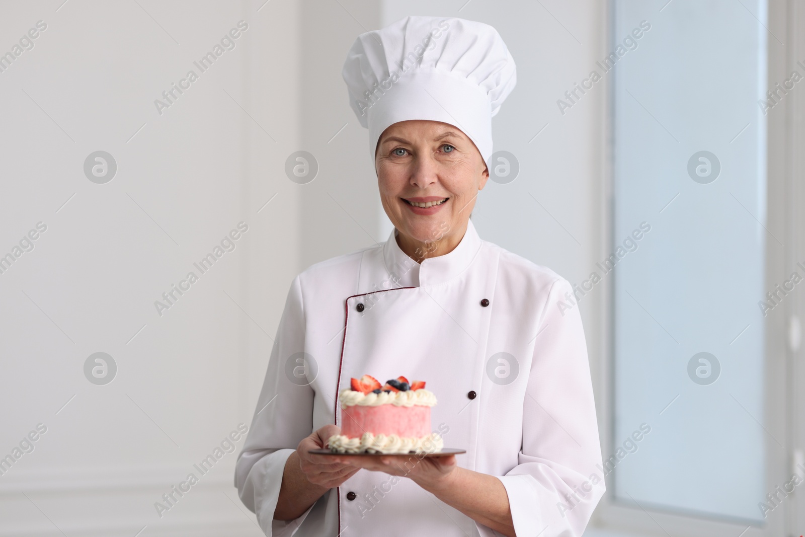 Photo of Professional pastry chef with cake in kitchen