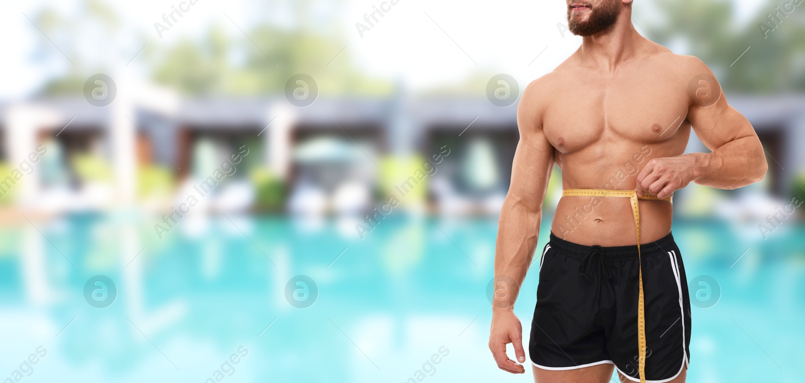 Image of Motivation to get fit for summer. Man with measuring tape showing his athletic body near swimming pool at sea resort, closeup. Banner design with space for text