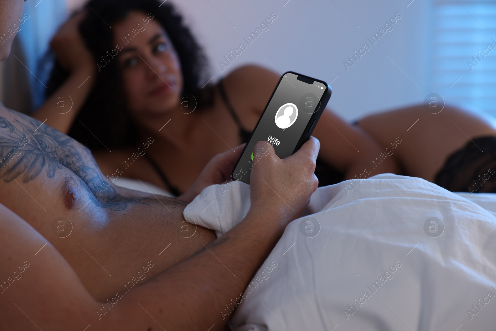 Image of Betrayal. Man getting phone call from his wife while he spending time with mistress on bed, closeup