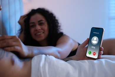 Betrayal. Man getting phone call from his wife while he spending time with mistress on bed, closeup