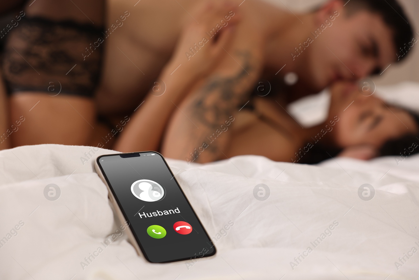 Image of Betrayal. Husband calling his wife on phone, while she spending time with other man on bed, selective focus