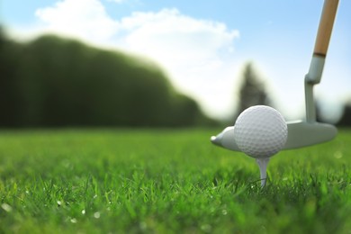 Photo of Hitting golf ball with club on green course, closeup. Space for text