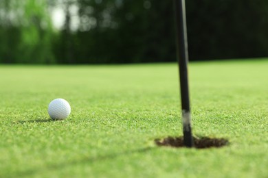 Golf ball near hole on green course