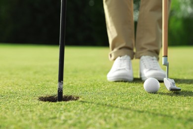 Person playing golf on green course, closeup