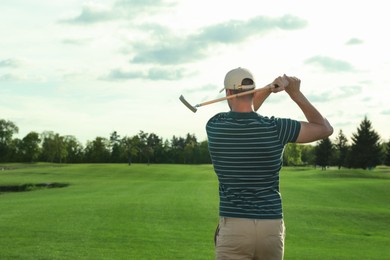 Man playing golf on green course, back view. Space for text