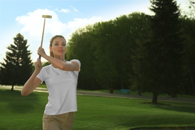 Photo of Beautiful woman playing golf on green course, space for text