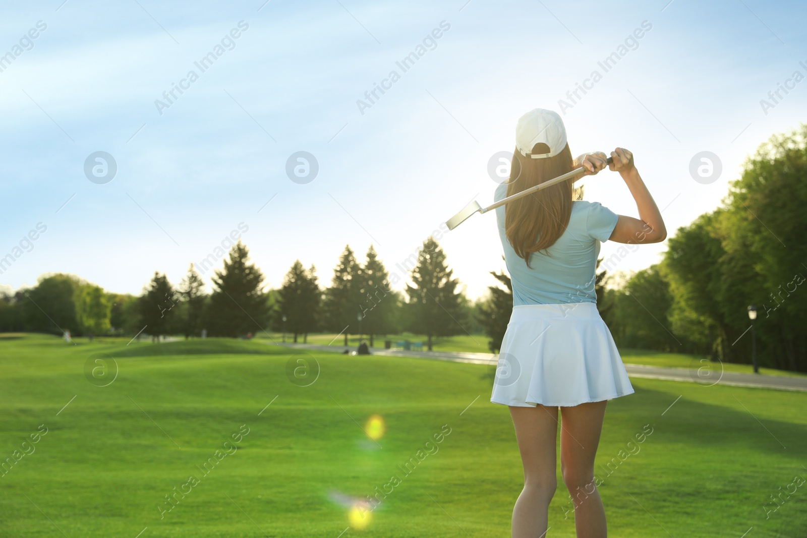 Photo of Woman playing golf on green course, back view. Space for text